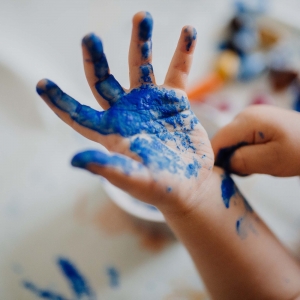Immagine di un bambino che si è sporcato le mani con la tempera.