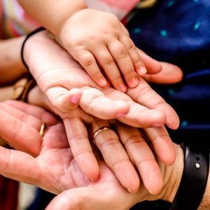 Immagine delle mani di un bambino e della sua famiglia.